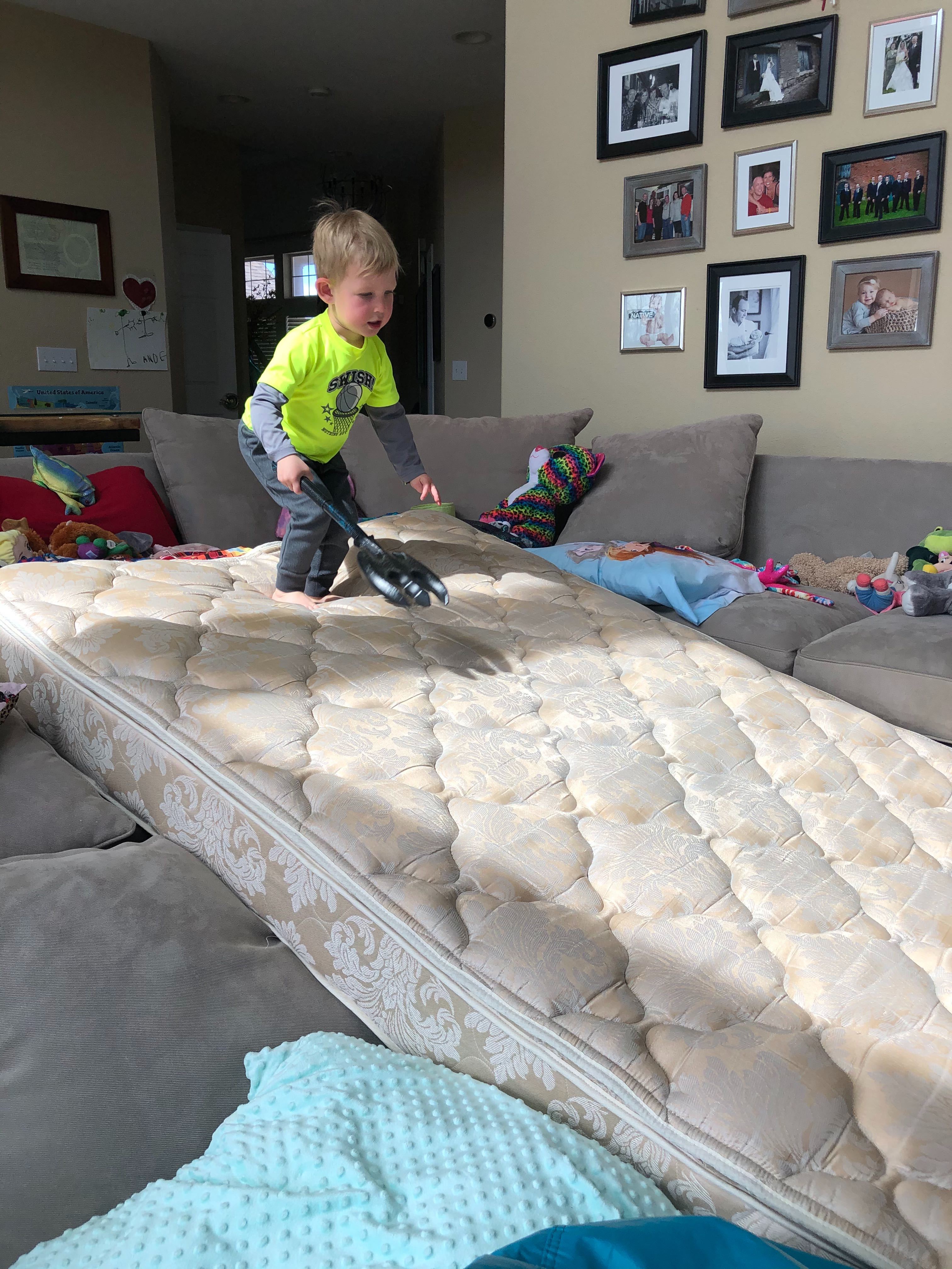 A young boy runs down a mattress mountain
